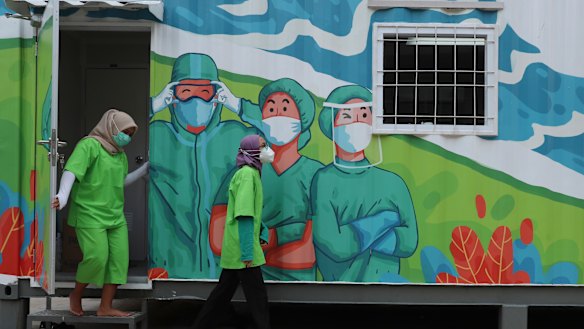 Health workers walk out of a mobile laboratory before analysing samples collected during mass coronavirus tests in Jakarta, Indonesia on Thursday.