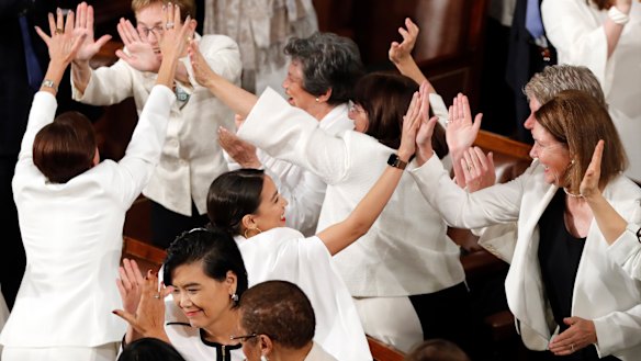 All in white in the house: Democrat congresswomen, including Alexandria Ocasio-Cortez, centre, cheer after President Donald Trump acknowledges more women in Congress during his State of the Union address.