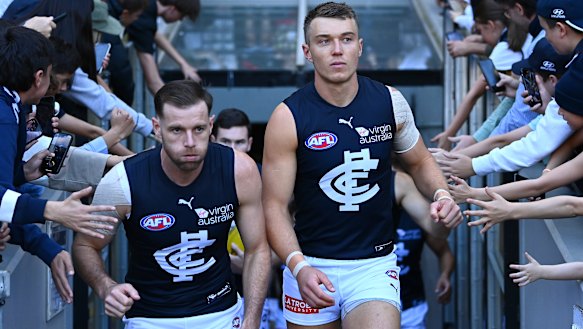 Sam Docherty and Patrick Cripps lead their team out on to the field during the round seven AFL match between the Bombers and the Blues.
