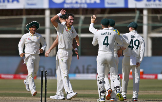 Mitchell Starc and the Australians celebrate the wicket of Hasan Ali in Karachi.