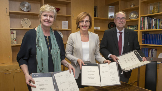 Peter MacCallum Cancer Centre board chair Maxine Morand, ACT health minister Meegan Fitzharris and ANU acting vice-chancellor Mike Calford celebrate signing a Memorandum of Understanding between the three bodies to bring world-leading cancer research to Canberra.