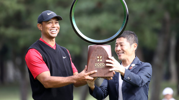 Golfer Tiger Woods receives the trophy from the Zozo founder Yusaku Maezawa at the Zozo Championship in Inzai, Chiba, Japan, last year.