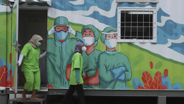 Health workers walk out of a mobile laboratory before analysing samples collected during mass coronavirus tests in Jakarta, Indonesia on Thursday.
