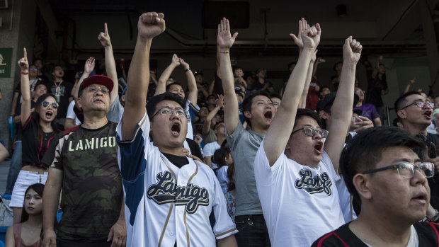 Fans of the Lamigo Monkeys baseball team cheer during a game at the Taoyuan International Baseball Stadium in Taoyuan City.