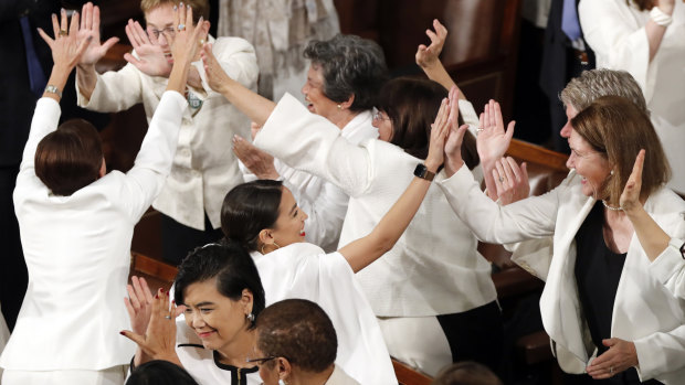 All in white in the house: Democrat congresswomen, including Alexandria Ocasio-Cortez, centre, cheer after President Donald Trump acknowledges more women in Congress during his State of the Union address.