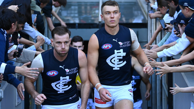 Sam Docherty and Patrick Cripps lead their team out on to the field during the round seven AFL match between the Bombers and the Blues.
