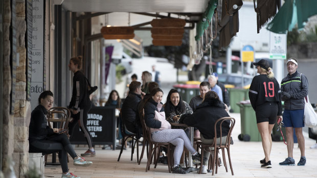 Loosening up slowly ... people gather at a cafe at Bronte Beach.