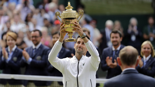Novak Djokovic lifts the Wimbledon men's trophy for a fifth time.