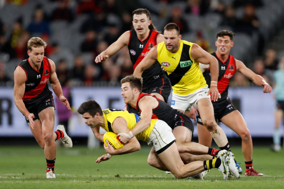 Trent Cotchin is tackled by Zach Merrett.