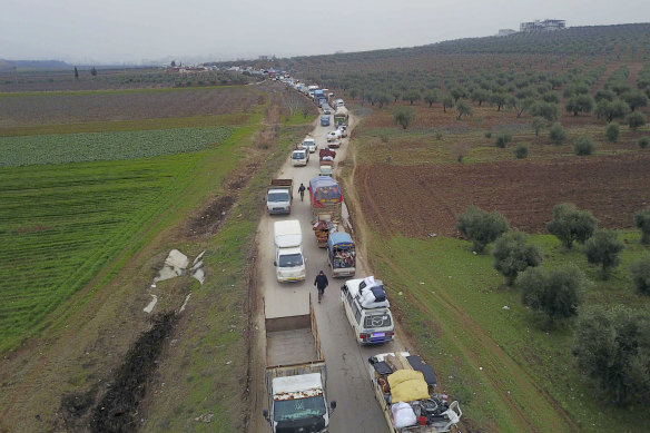 Civilians flee from Idlib to find safety inside Syria near the border with Turkey on Tuesday.