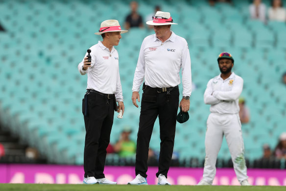 Umpires Chris Gaffaney and Paul Reiffel consult the light meter during the Sydney Test.