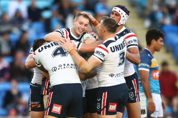 Sam Walker is mobbed by teammates after a try against the Titans.