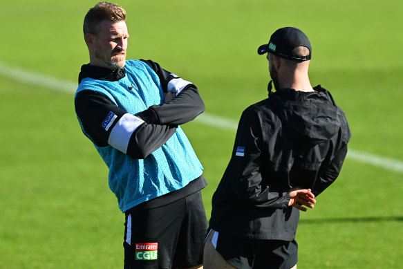 Magpies coach Nathan Buckley chats to Steele Sidebottom at training.