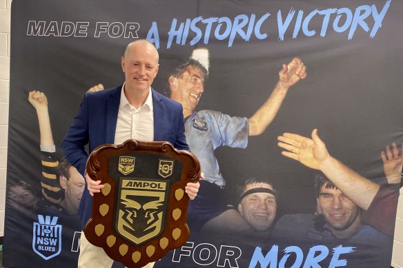 NSW Blues coach Michael Maguire poses with the State of Origin shield after his side’s series win at Suncorp Stadium.