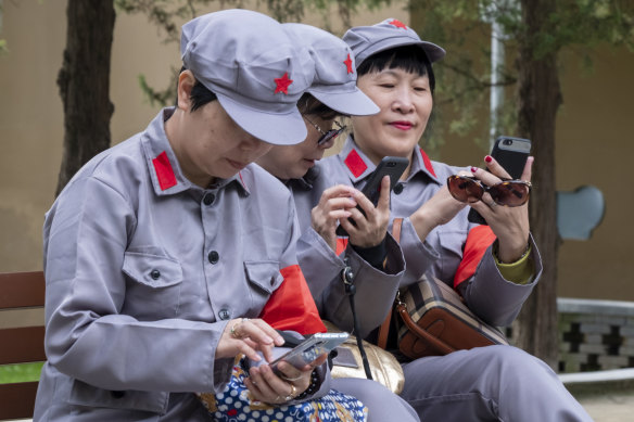 Chinese tourists dressed in Long March uniforms use technology that was beyond the wildest dream of Yan'an's revolutionaries. 