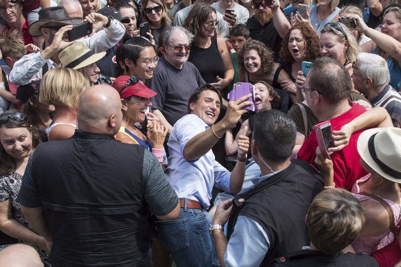 Prime Minister Justin Trudeau, centre left, takes a selfie with a person in a wheelchair during a visit to Penticton, British Columbia in 2018.