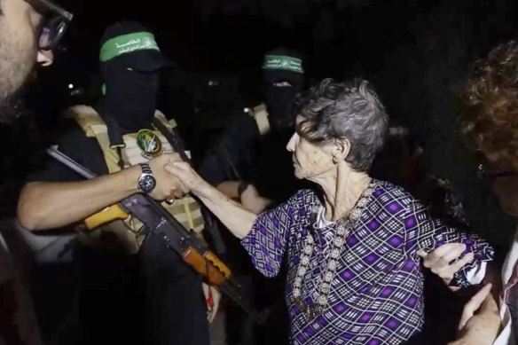 This image taken from video released by Al Qassam brigades on its Telegram channel, shows Yocheved Lifshitz, 85, shaking hands and thanking a member of Hamas as she is released to the Red Cross.