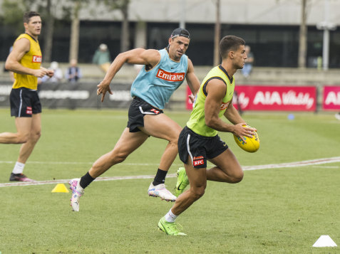 Scott Pendlebury chases Nick Daicos at Collingwood training on Friday.