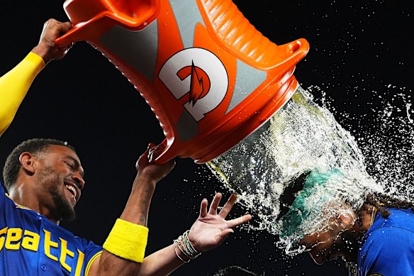 Julio Rodriguez douses J.P. Crawford after Crawford hit a game-winning home run to beat the Texas Rangers in a baseball game in Seattle.