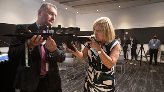 Detective Inspector Mick Daly shows Police Minister Lisa Neville an illegal guns seized by police during the launch of the Victoria Police Illicit Firearms Unit in Melbourne. 
