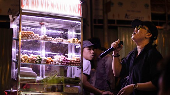 A street vendor and karaoke singer performs on Bui Vien Street, Ho Chi Minh, Vietnam. 