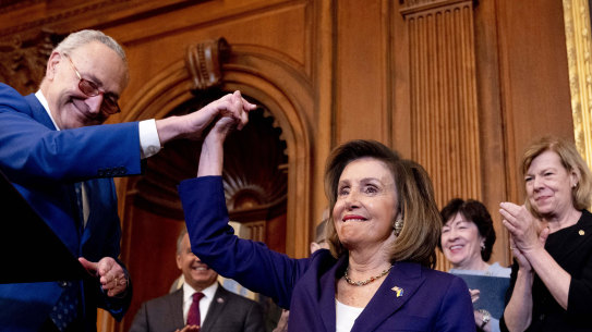 Senate Majority Leader Senator Chuck Schumer of NY, left, high-fives House Speaker Nancy Pelosi , as he praises her before she signs the Respect For Marriage Act in Washington.