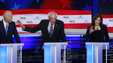 Democratic presidential candidate Senator Bernie Sanders, centre, gestures towards former vice-president Joe Biden as Kamala Harris talks.