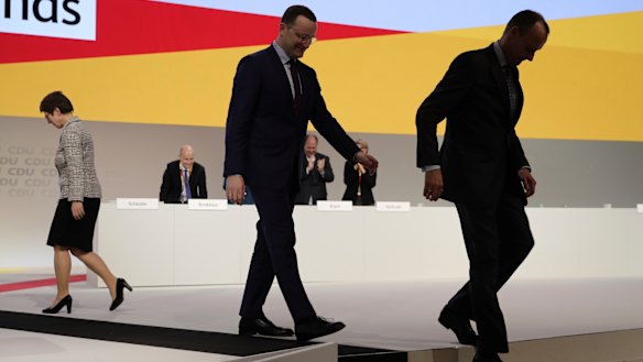 Candidates Jens Spahn and Friedrich Merz, right, leave the podium after Annegret Kramp-Karrenbauer won the vote. 