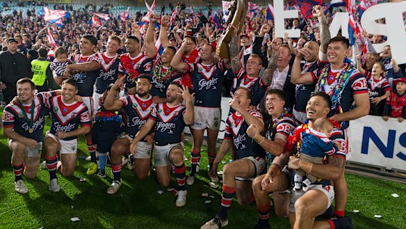 Cock-a-hoop: Sydney Roosters players celebrate in front of their faithful after their grand final victory. 