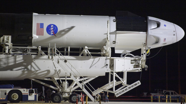 A SpaceX Falcon 9 rocket with the company's Crew Dragon spacecraft is rolled out of the horizontal integration facility at Launch Complex 39A at NASA's Kennedy Space Center in Cape Canaveral, Florida. 