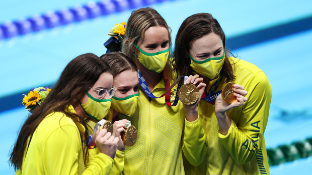 The women’s medley relay winners display their gold medals.
