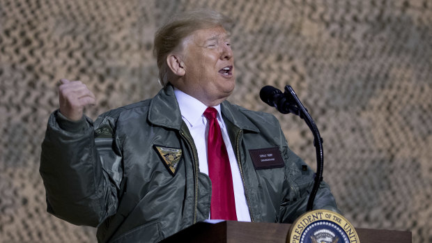 President Donald Trump speaks at a hanger rally at Al Asad Air Base, Iraq, on  December  26 at which he defended his surprise decision to pull troops from Syria.