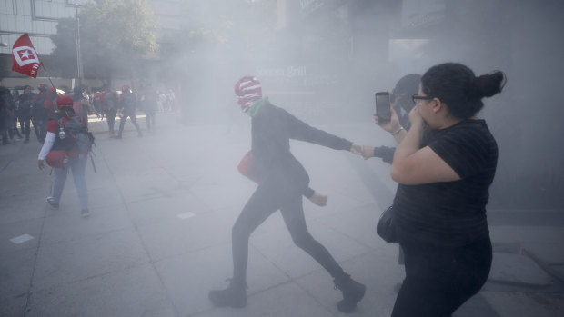Demonstrators are surrounded by a cloud of tear gas during an International Women's Day march in Mexico City.