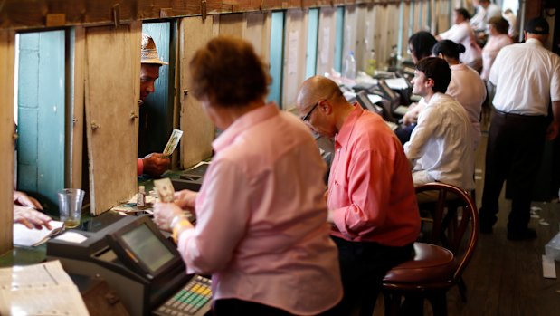 Workers take bets before the 144th running of the Kentucky Oaks horse race on May 4.