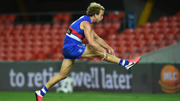 Off the leash: Mitch Wallis boots a goal for the Dogs.