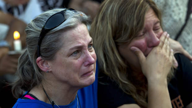 Carol Geithner, left, and Yasemin Jamison gather for a candlelight vigil.