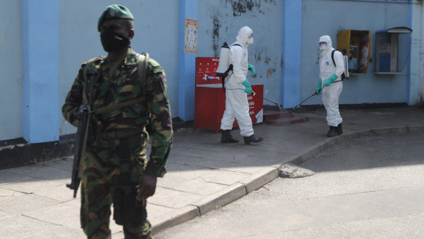 Police commandos prepare to spray disinfectant in a hospital in Colombo on March 27.