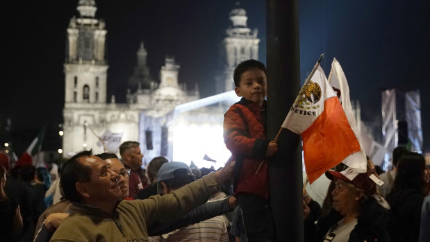 A child holds a Mexican flag as supporters of presidential candidate Andres Manuel Lopez Obrador celebrate his victory, on Mexico City's Madero main square, the Zocalo, on Sunday.
