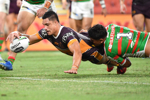 Kotoni Staggs (left) of the Broncos scores a try despite the efforts of Latrell Mitchell.