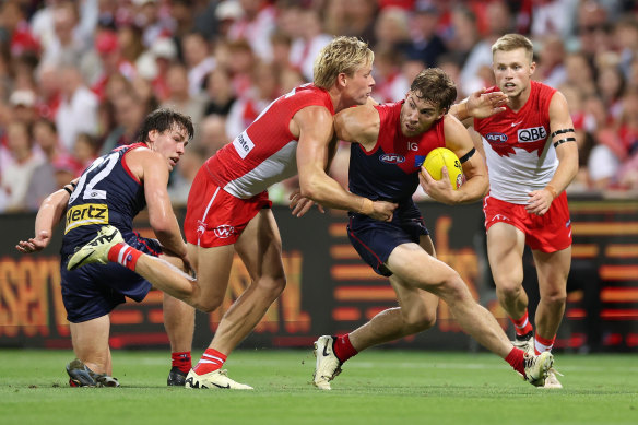 Demons vice captain Jack Viney is tackled by Swans star Isaac Heeney.