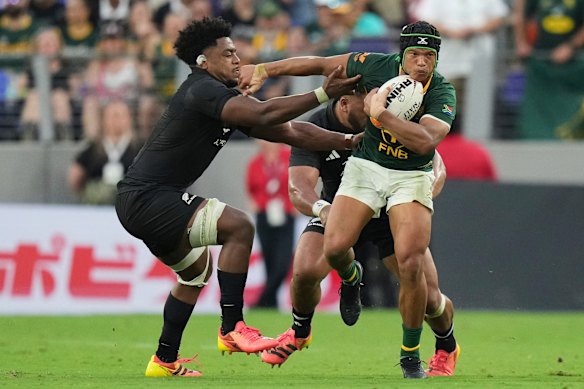 South Africa’s Kurt-Lee Arendse, right, attempts to break the tackle of New Zealand’s Peter Lakai.