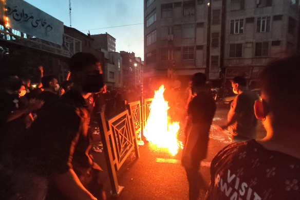 Protesters make a fire and block the street during a protest over the death of a woman who was detained by the morality police, in downtown Tehran, Iran.