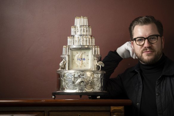 Samuel Fricker, from Gibson’s auction house, with the sterling silver centenary cake.