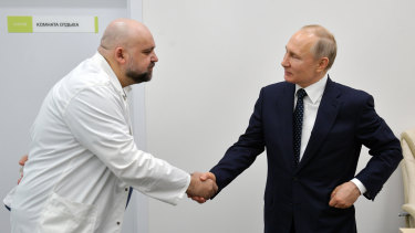 Russian President Vladimir Putin, right shakes hands with Kommunarka hospital's chief Denis Protsenko during his visit outside Moscow, Russia.