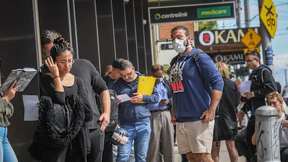 People queue for welfare payments after losing their jobs.