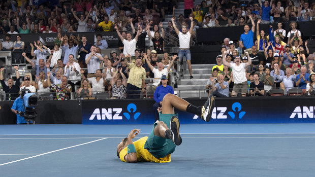 Nick Kyrgios falls to the ground after winning his singles match.
