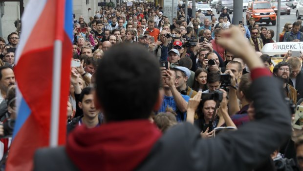 Russian opposition candidate and activist Ilya Yashin, back to a camera, speaks to a crowd during a protest in Moscow.