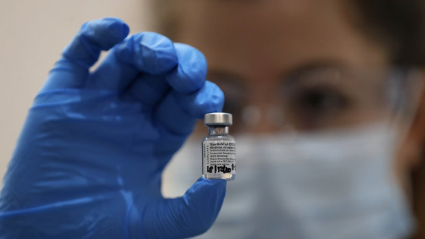 A nurse holds a phial of the Pfizer-BioNTech vaccine – one of two products being rolled out in Australia.