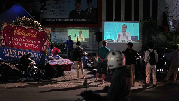 People watch last month's second presidential debate on the street in Jakarta.