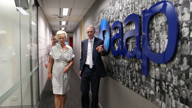 Campbell Reid (right) and Emma Cowdroy walk away after the closure announcement at AAP head office in Sydney.